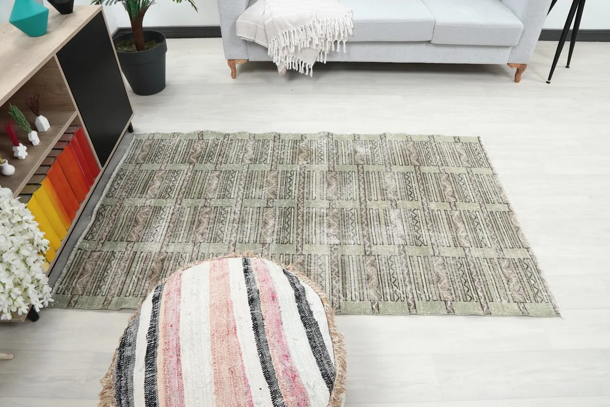Full room view of the olive geometric rug complementing the light decor