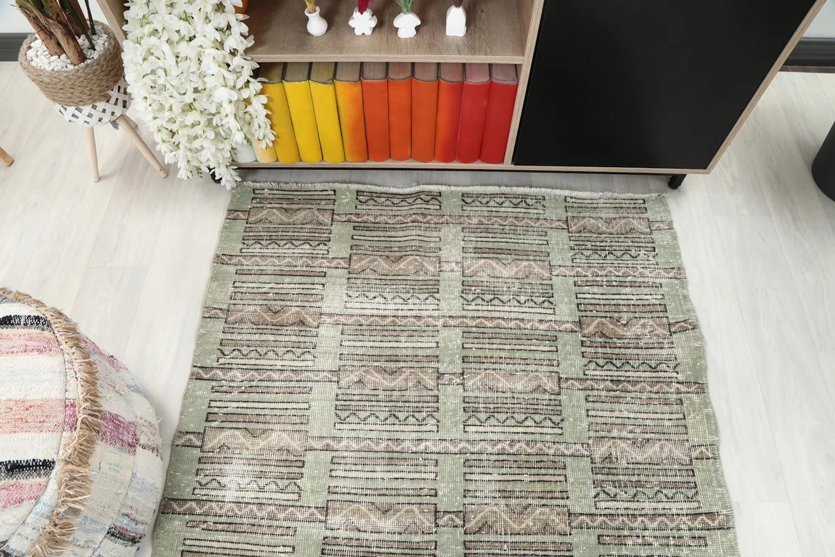 Overhead view of the olive tribal rug in a room setting from a slight angle