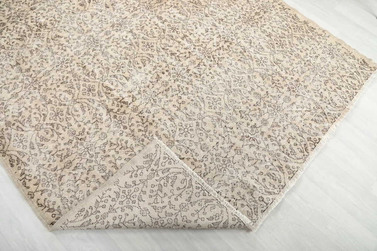 Corner of the rug folded back, revealing the reverse side and construction details.