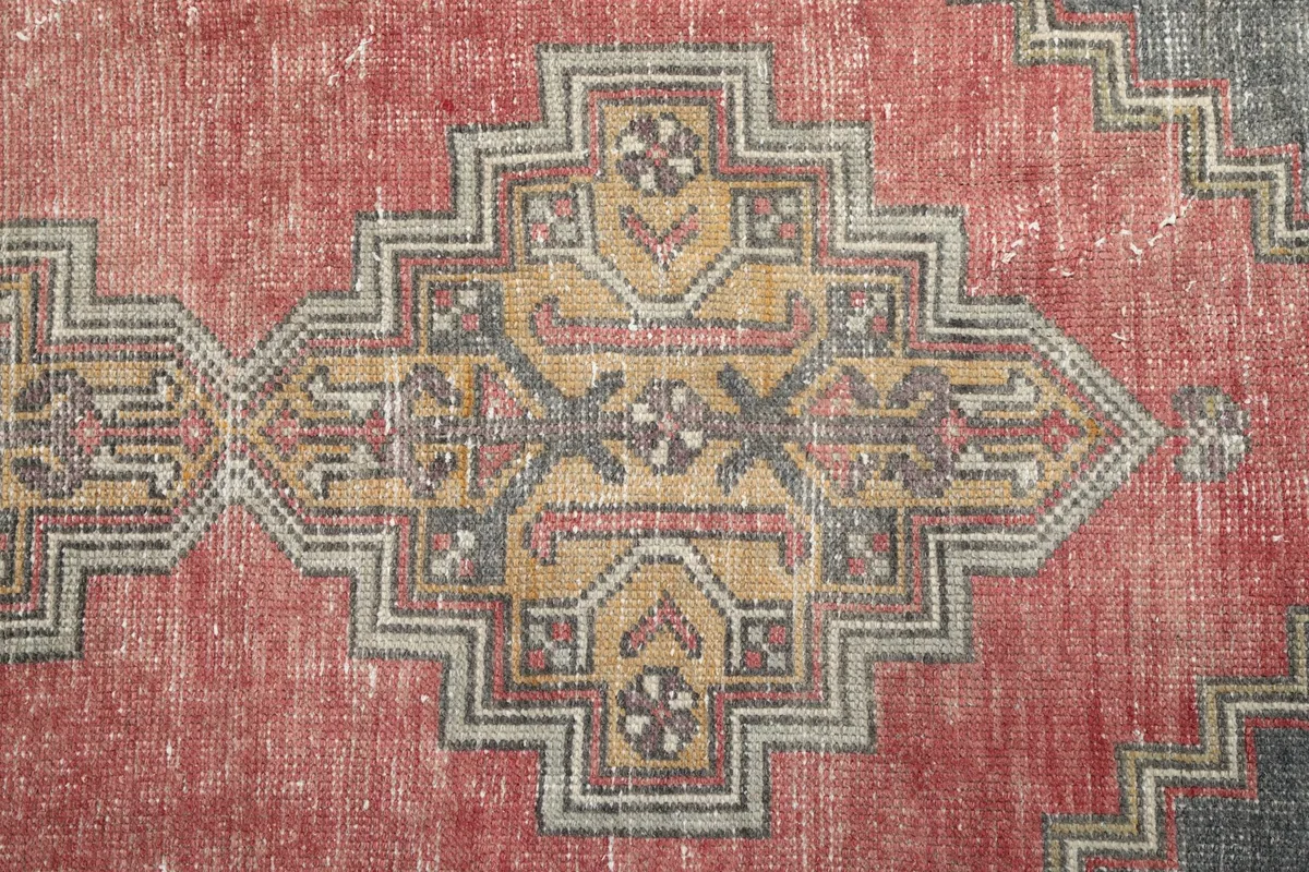 Close-up of the central geometric medallion and faded rose pile