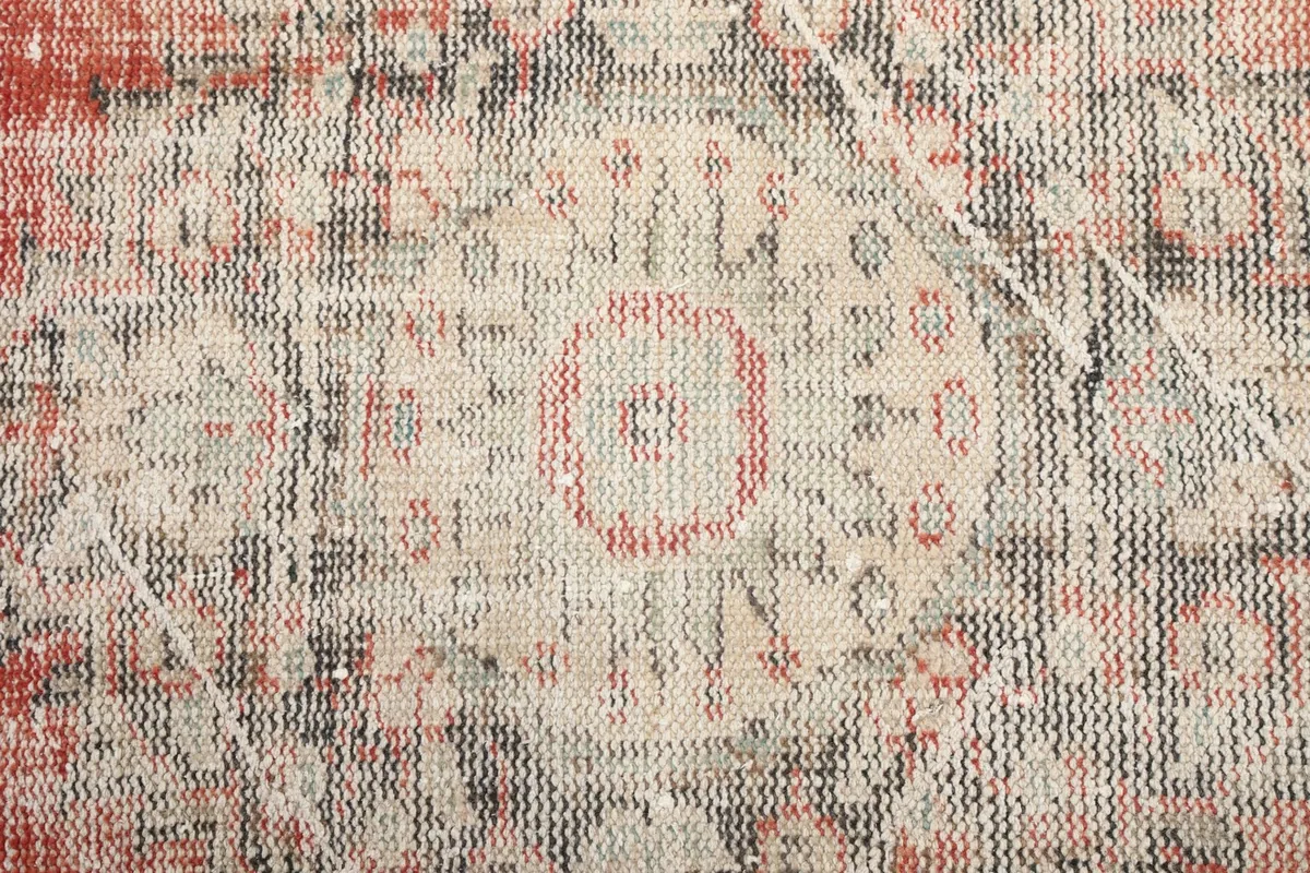 Extreme close-up of the central medallion's intricate, faded geometric pattern.