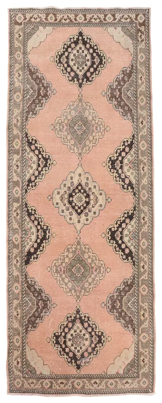 Full overhead view of a rose colored vintage Anatolian runner rug with geometric medallions