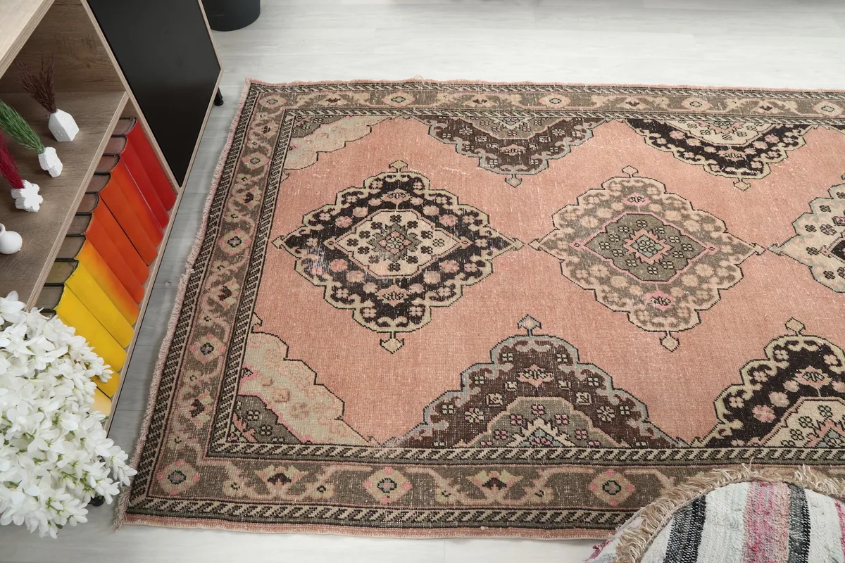 Angled view of the rug's patterns and colors from above, showing room context