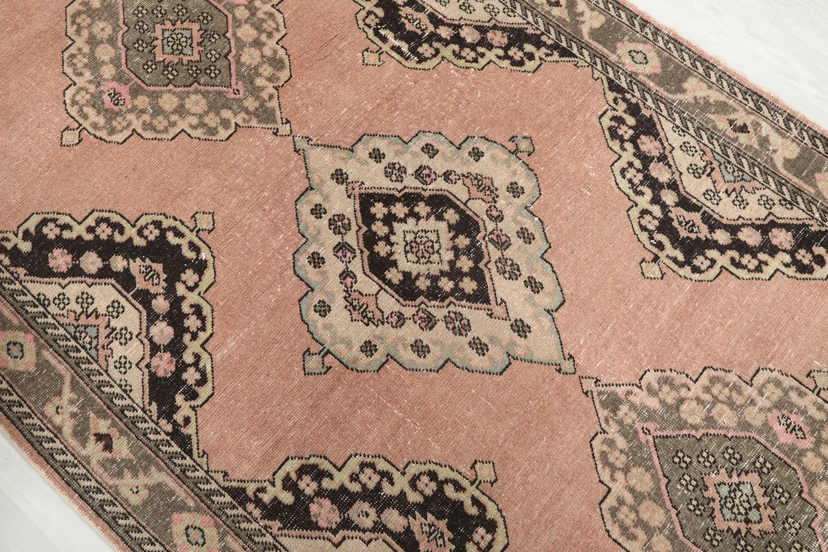 Close view of repeating geometric medallion motifs on the rose runner