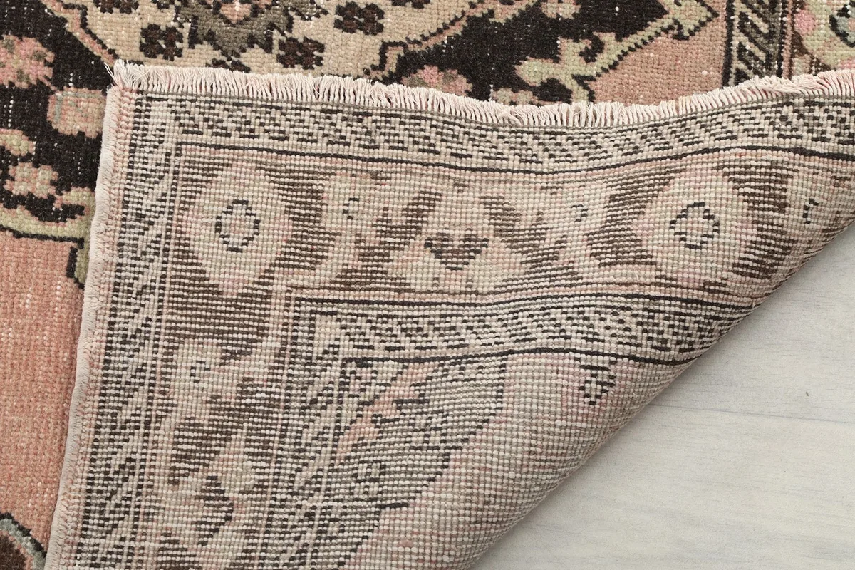 Close-up of the rug's edge, showing the short fringe and the reverse side