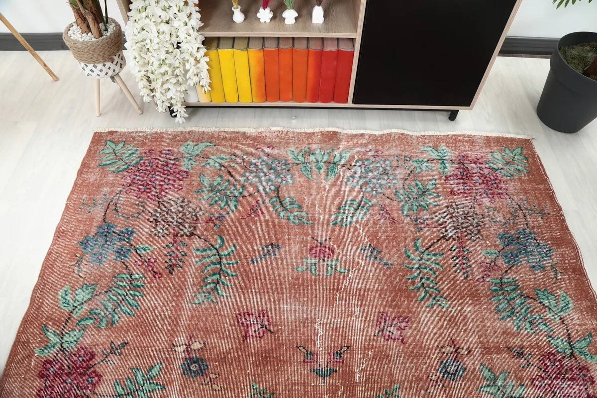 Overhead angle view showing the rug's top edge and floral design extending into the field