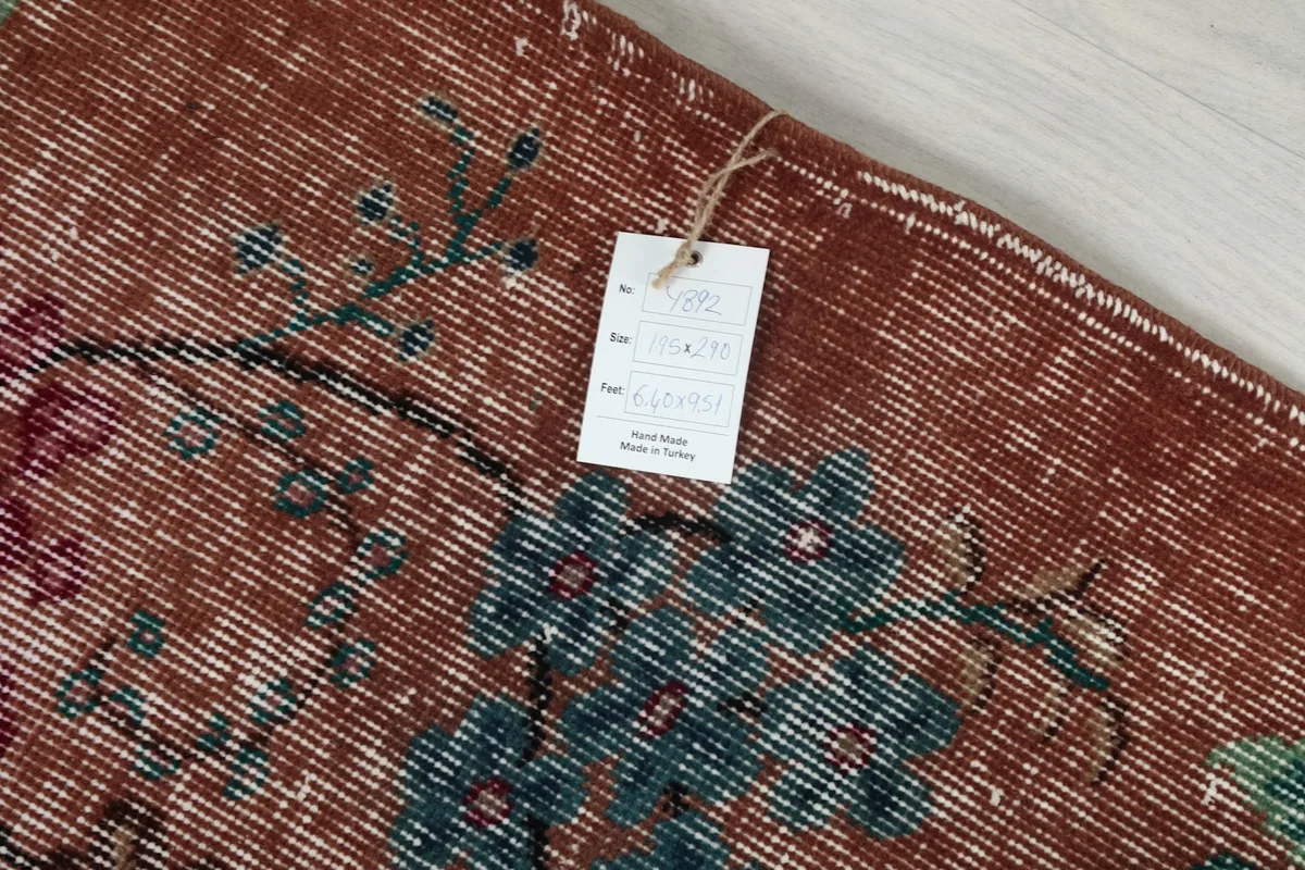 Back of the rug with a tag indicating origin from Turkey and hand-knotted wool material