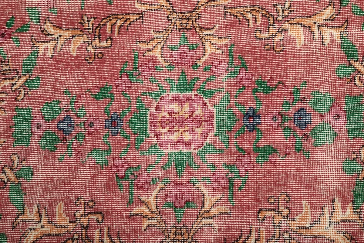 Close-up of the central medallion design, showing rose, green, and blue colors