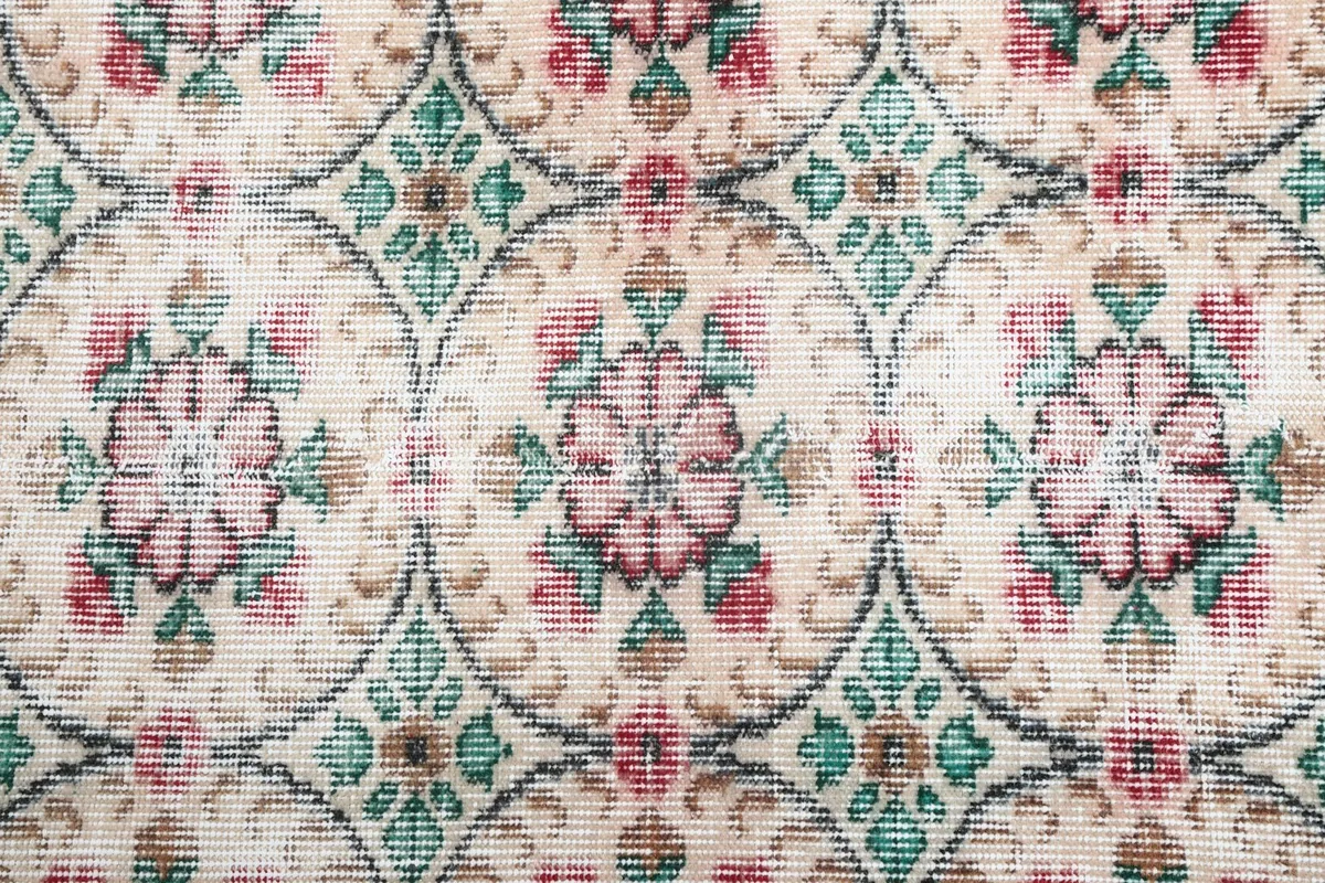 Detailed close-up of the hand-knotted wool pile and the intricate rose and green motifs