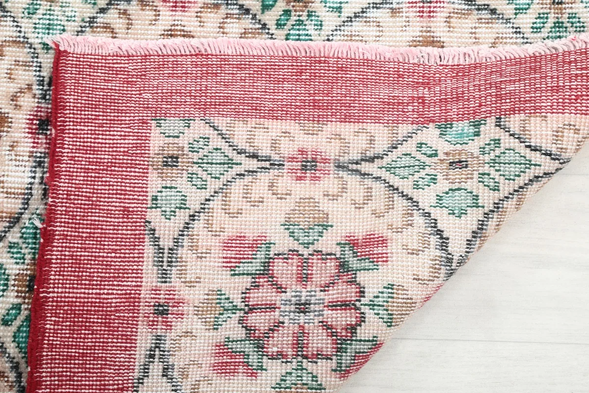 Underside of the rug showing the hand-knotted cotton foundation and the reverse of the pattern
