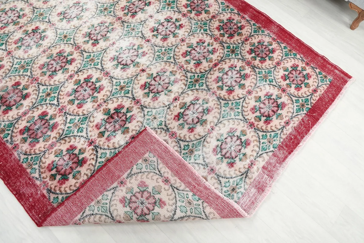 Corner of the vintage rug folded back, revealing the wool pile and cotton foundation
