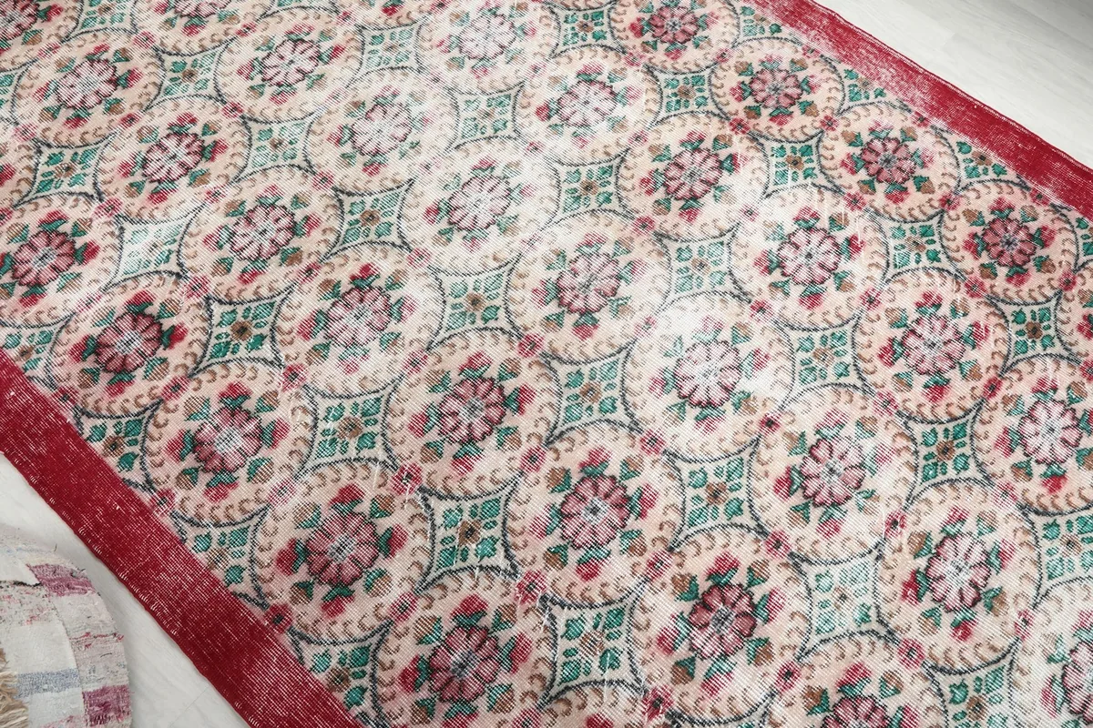 Overhead view of the rug's central design, featuring repeating geometric floral medallions