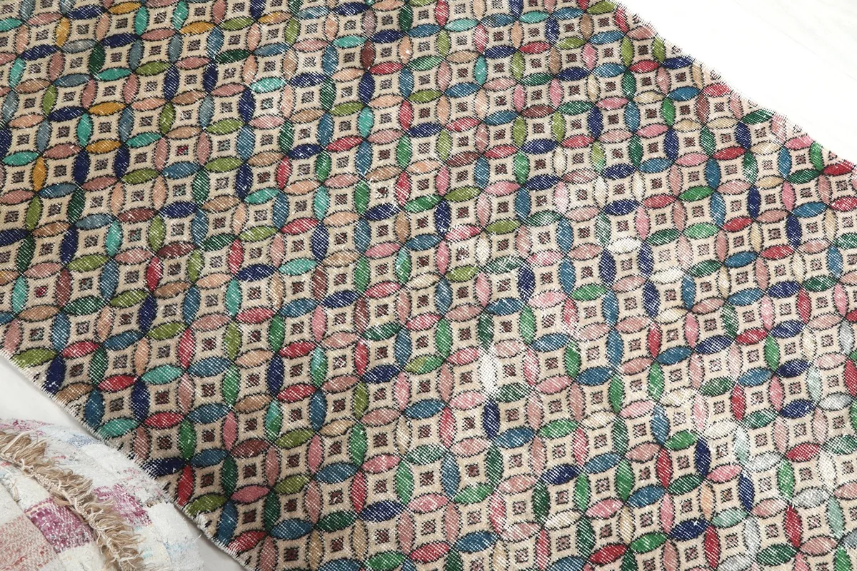 Diagonal view showcasing the full length of the multicolor geometric pattern on the vintage runner