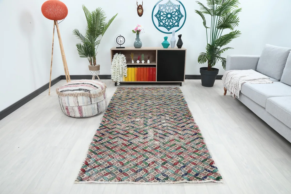 Multicolor geometric vintage runner rug in a living room setting with a sofa and ottoman