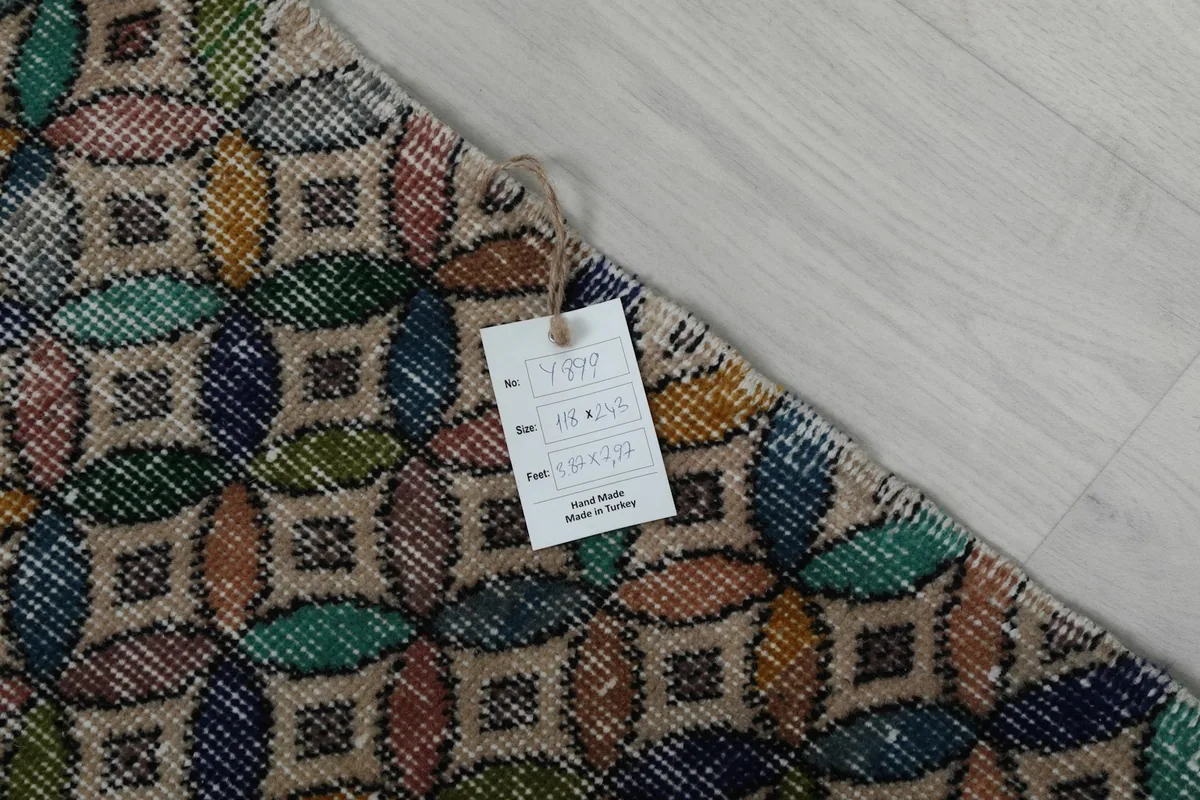 Corner of the rug with a tag indicating its size and origin, showing the multicolor pattern