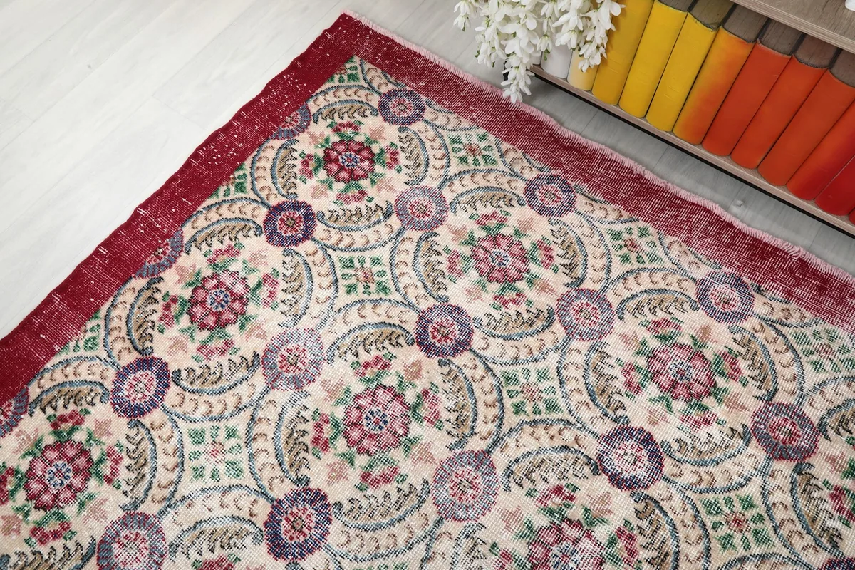 Angled view highlighting the intricate patterns and colors of the cream and red rug