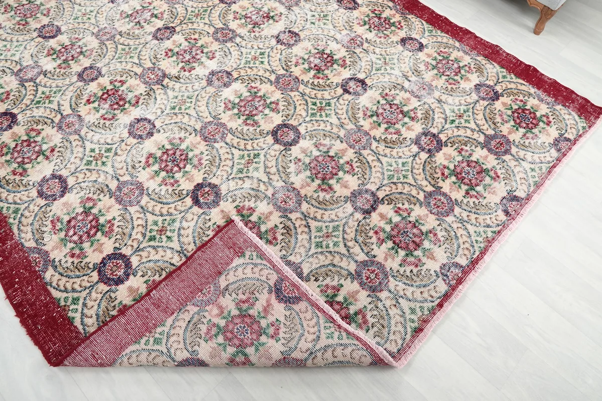 View of the rug folded back to show the cotton foundation and reverse side of the pattern