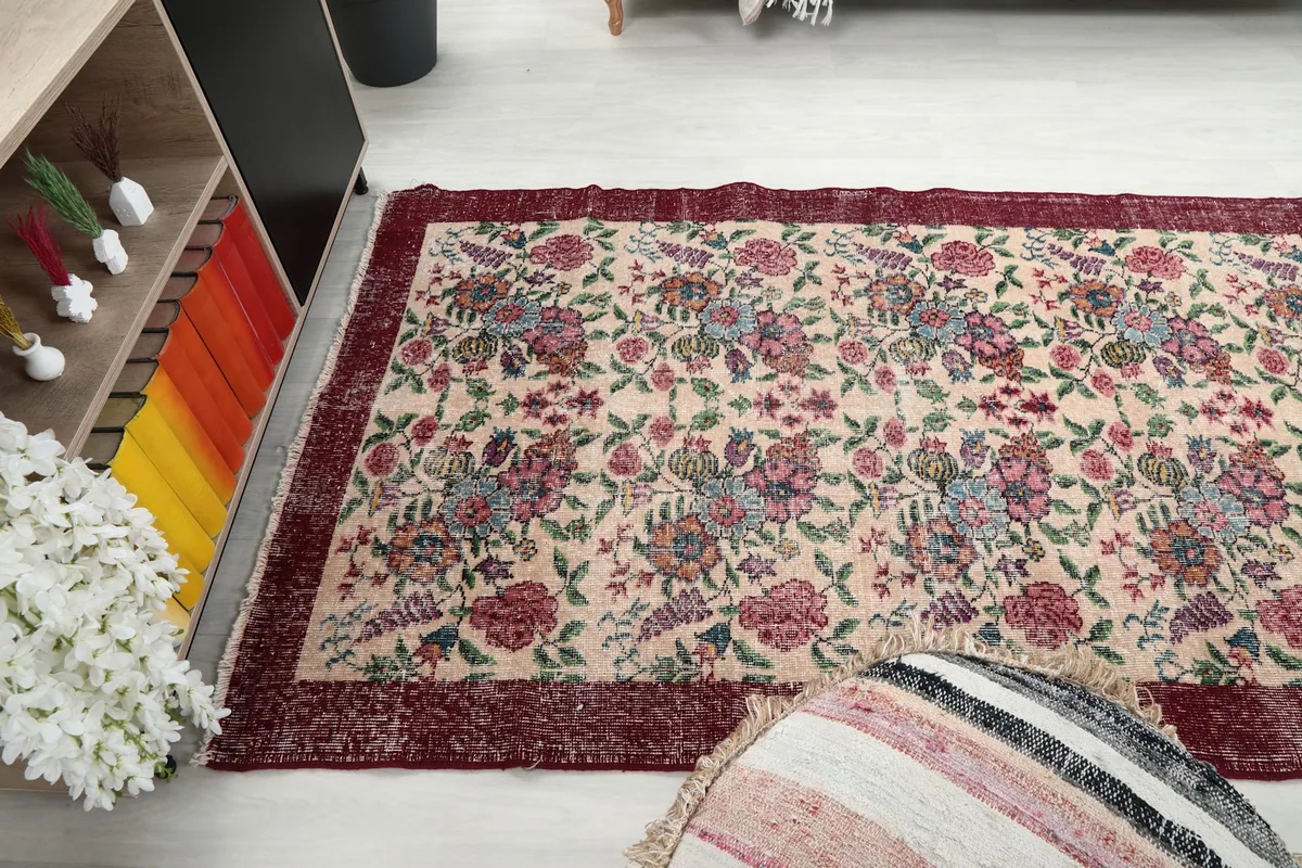 Wide shot of the rug in a room, showcasing its vibrant colors and vintage appeal as a focal point.