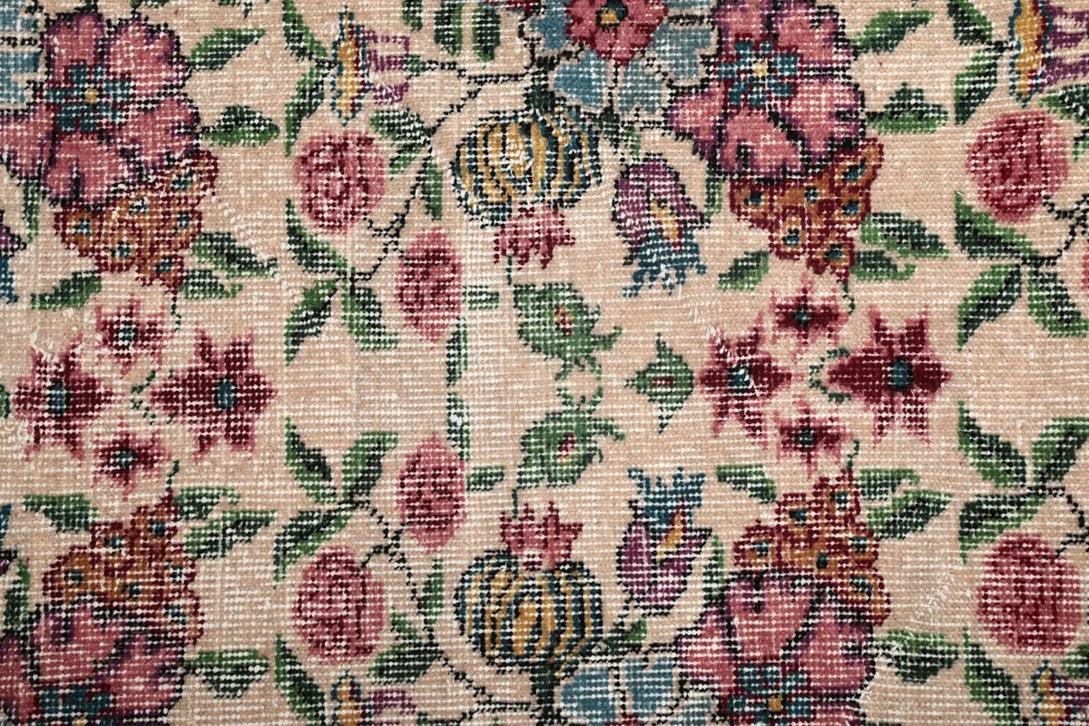 Close-up of the hand-knotted wool pile, revealing the intricate floral motifs in rose, blue, green, and orange.