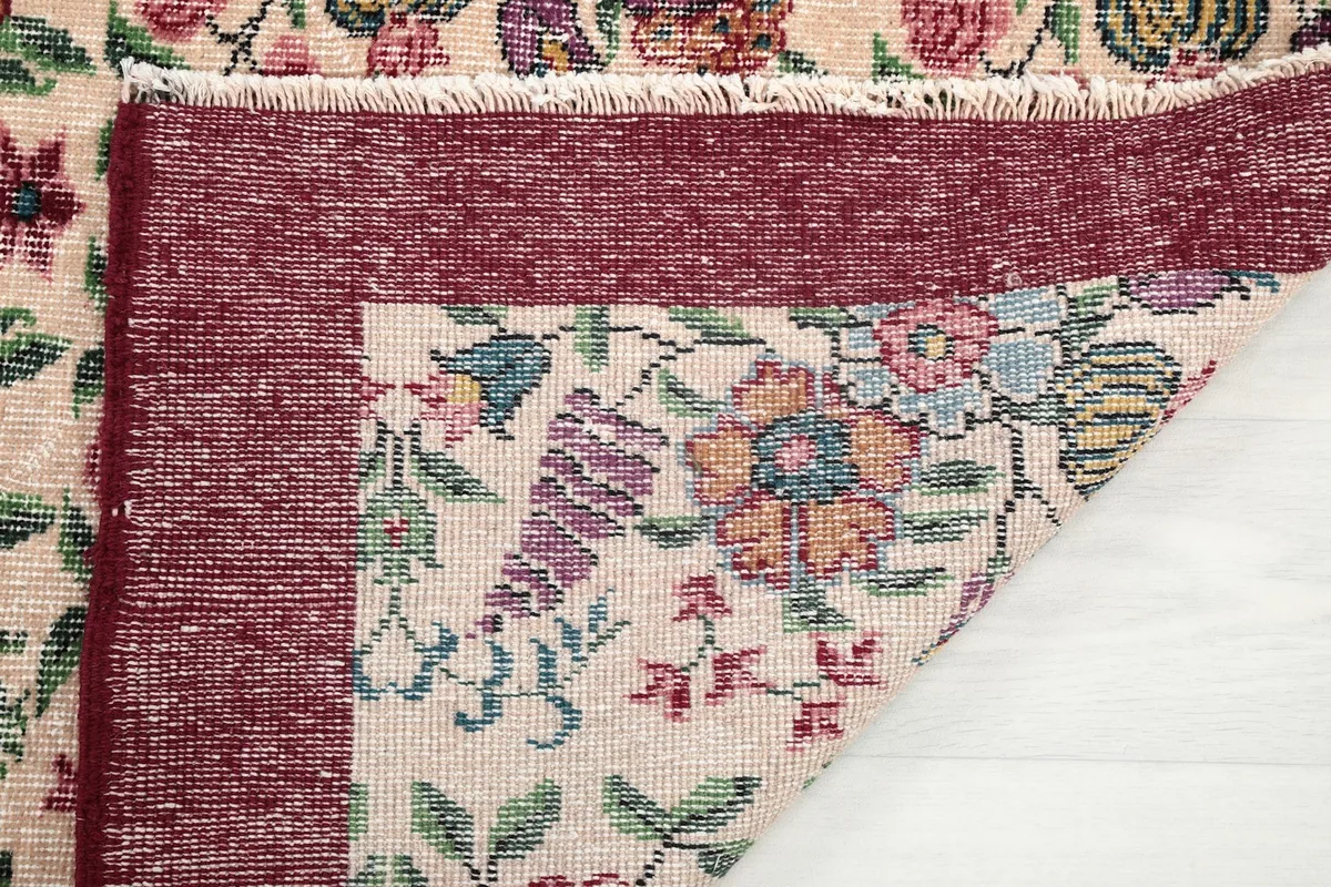 Detail of the rug's fringe and the back of the cotton foundation, indicating craftsmanship.