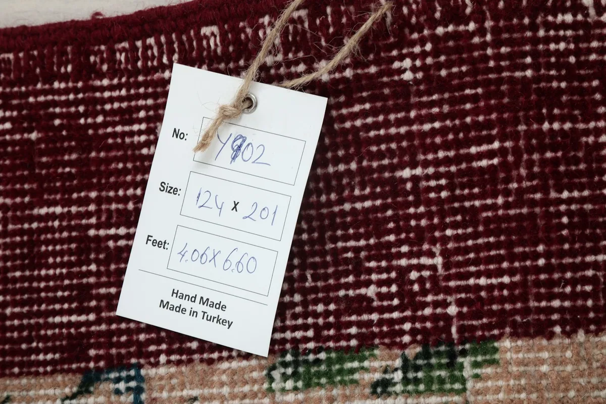 Tag showing the rug's dimensions in centimeters and feet, confirming its origin and hand-made nature.