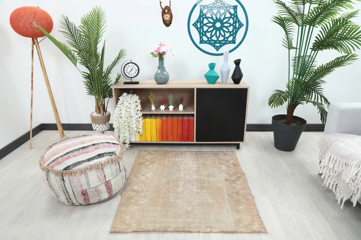 Faded beige rug in a living room setting, showing its size and neutral tones with furniture