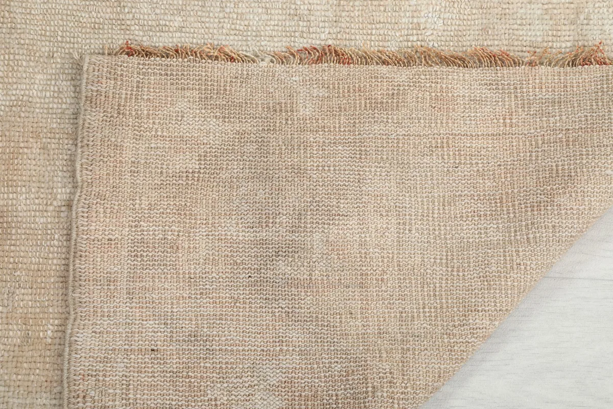 Underside view of the rug, showing the cotton foundation and the reverse of the knotting