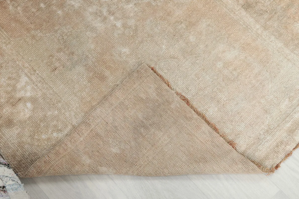 Folded corner of the rug, revealing the thickness and the back of the hand-knotted wool