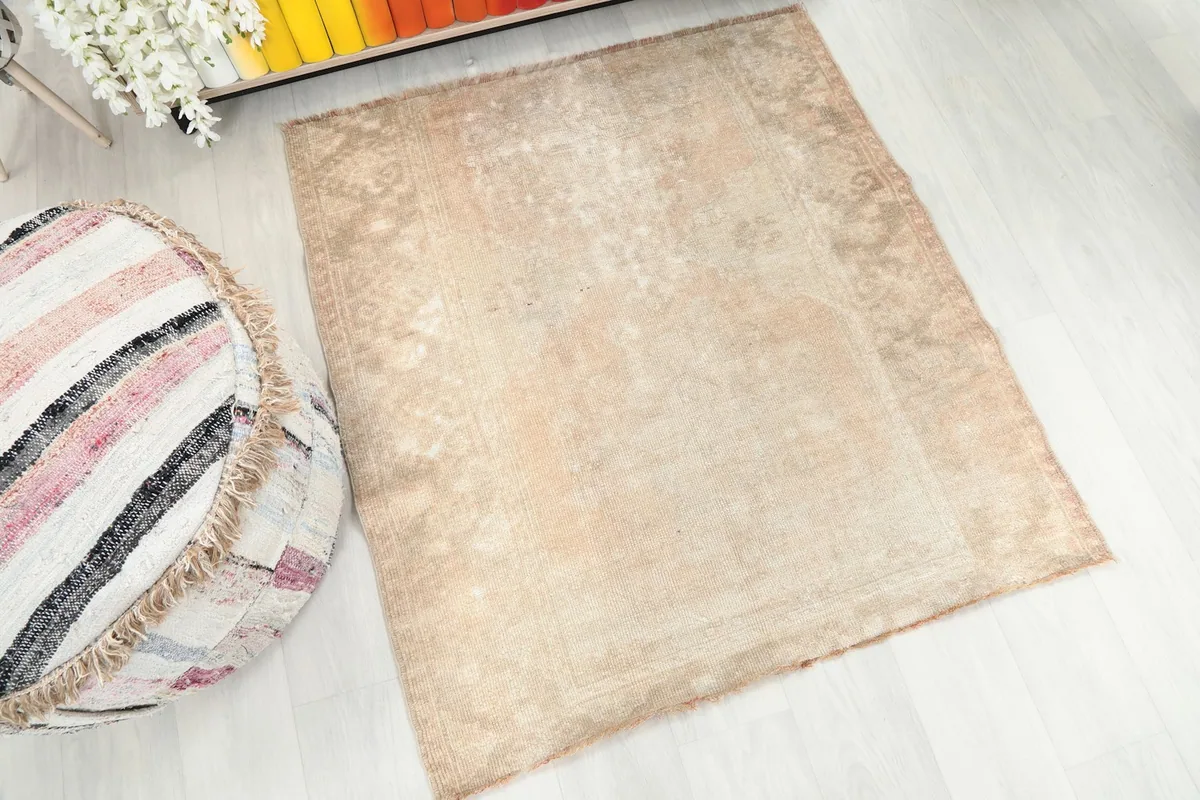 Overhead view of the beige rug, showing its overall shape and subtle geometric design