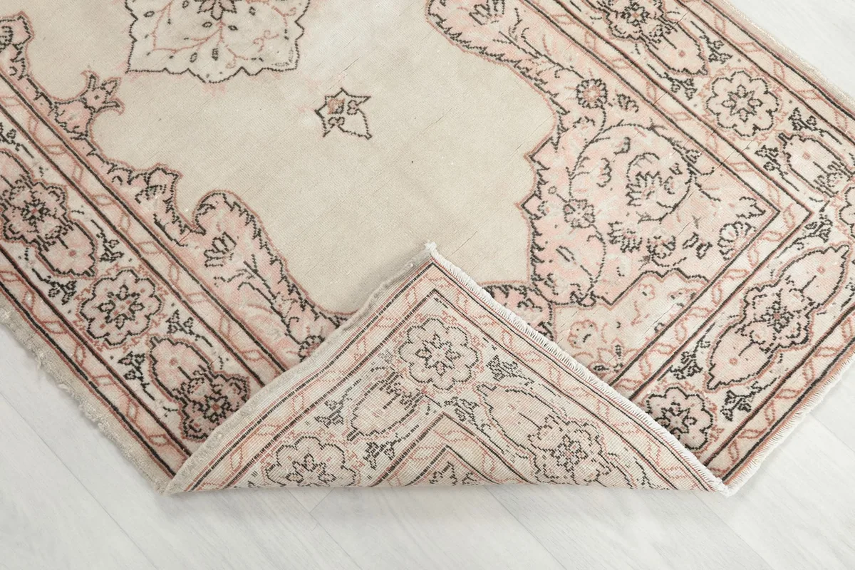 Folded corner of the rug, revealing the soft wool pile and hand-knotted texture