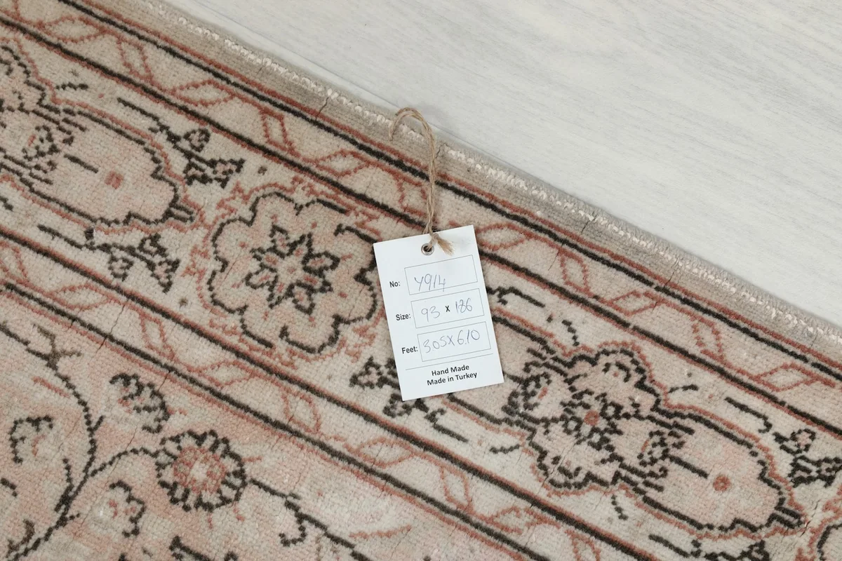 Tag on the rug displaying its size, origin, and material details