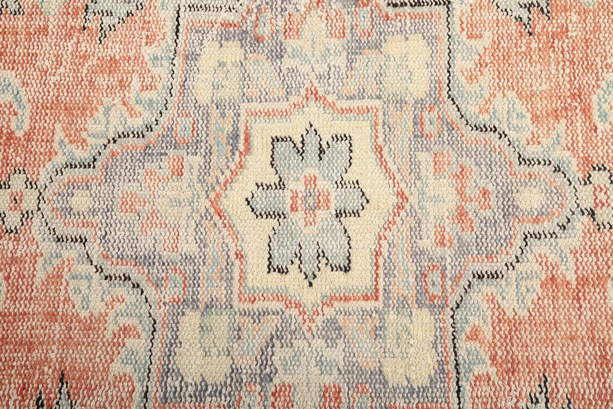 Detailed view of the intricate motifs within the central medallion of the rug.
