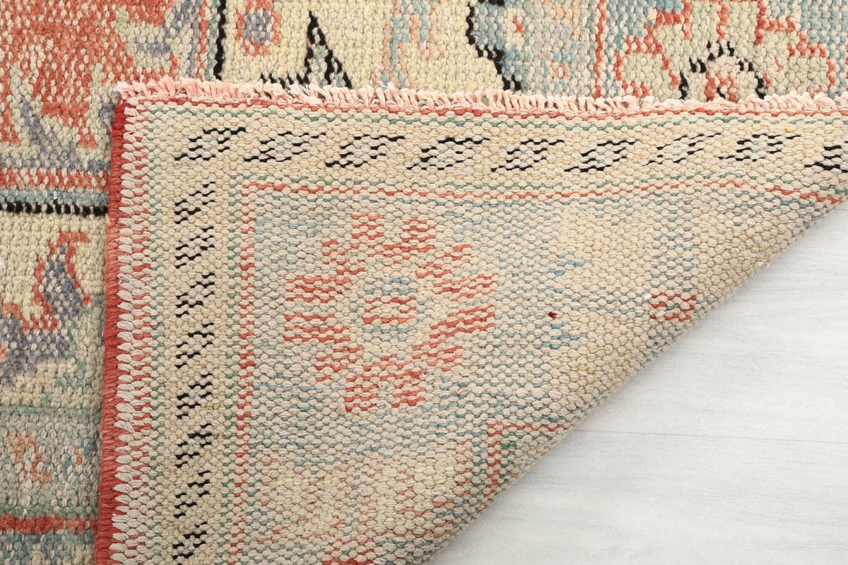 Underside of the rug showing the tight hand-knotted construction and fringe details.