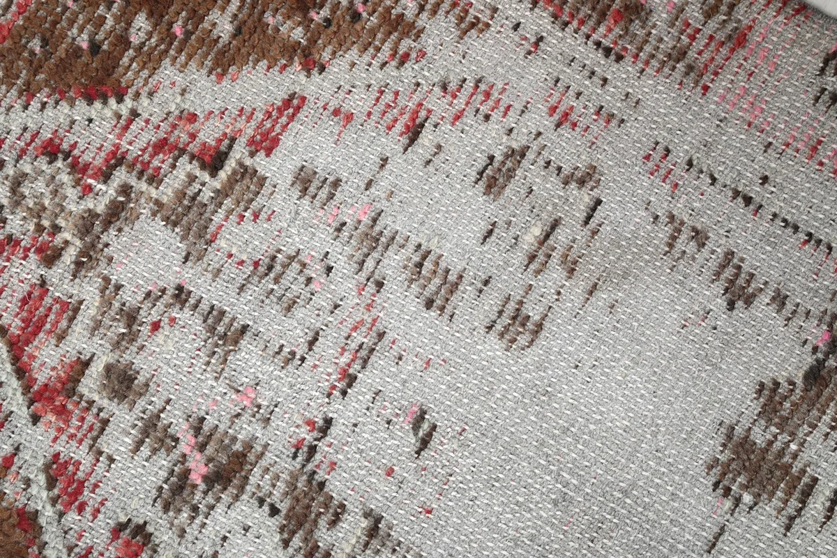 Close-up of the low wool pile and distressed texture, showing the knotting and wear.