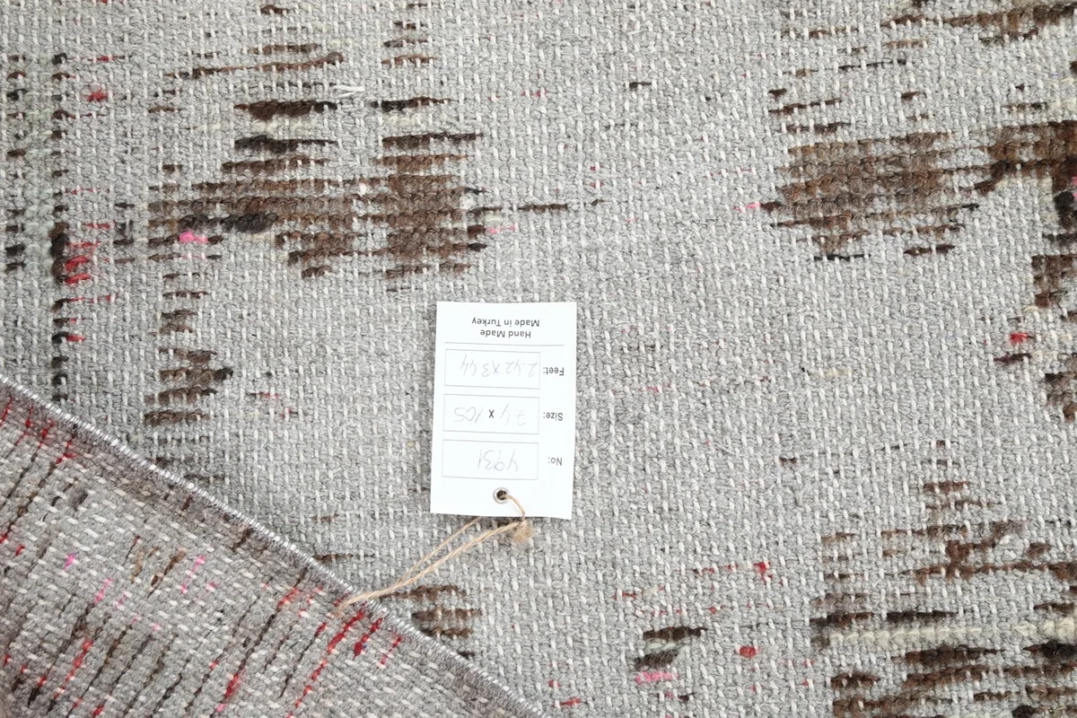 Close-up of the rug's back, showing the weave and product tag for authenticity.