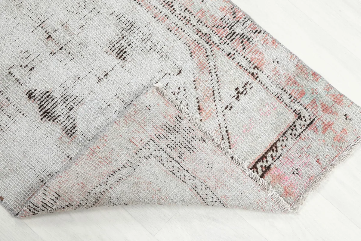 Folded corner of the rug, showing the wool pile and cotton foundation