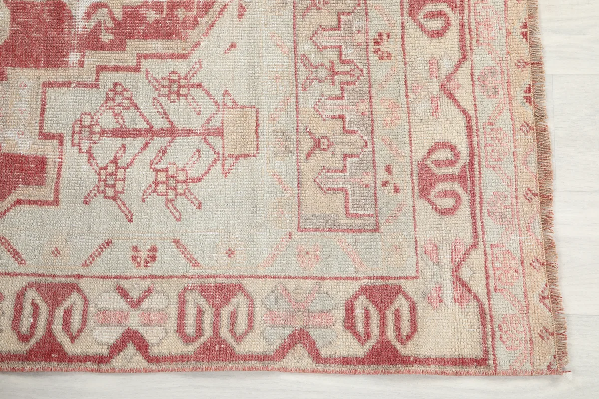 Detailed corner of the Faded Rose Geometric Anatolian Rug, revealing the intricate tribal patterns and faded rose hues.