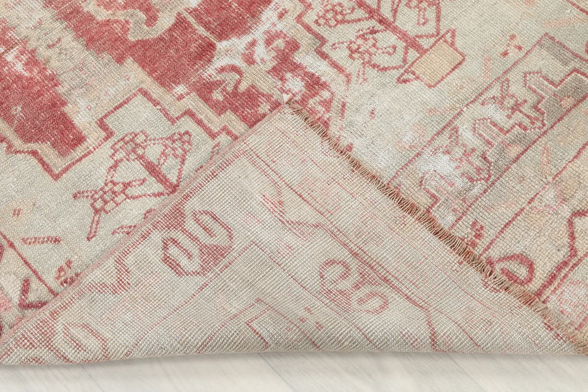 Folded corner of the Faded Rose Geometric Anatolian Rug, revealing the hand-knotted cotton foundation and wool pile.