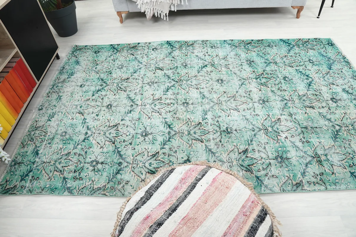 Overhead view of the green rug in a room with furniture, showing its size