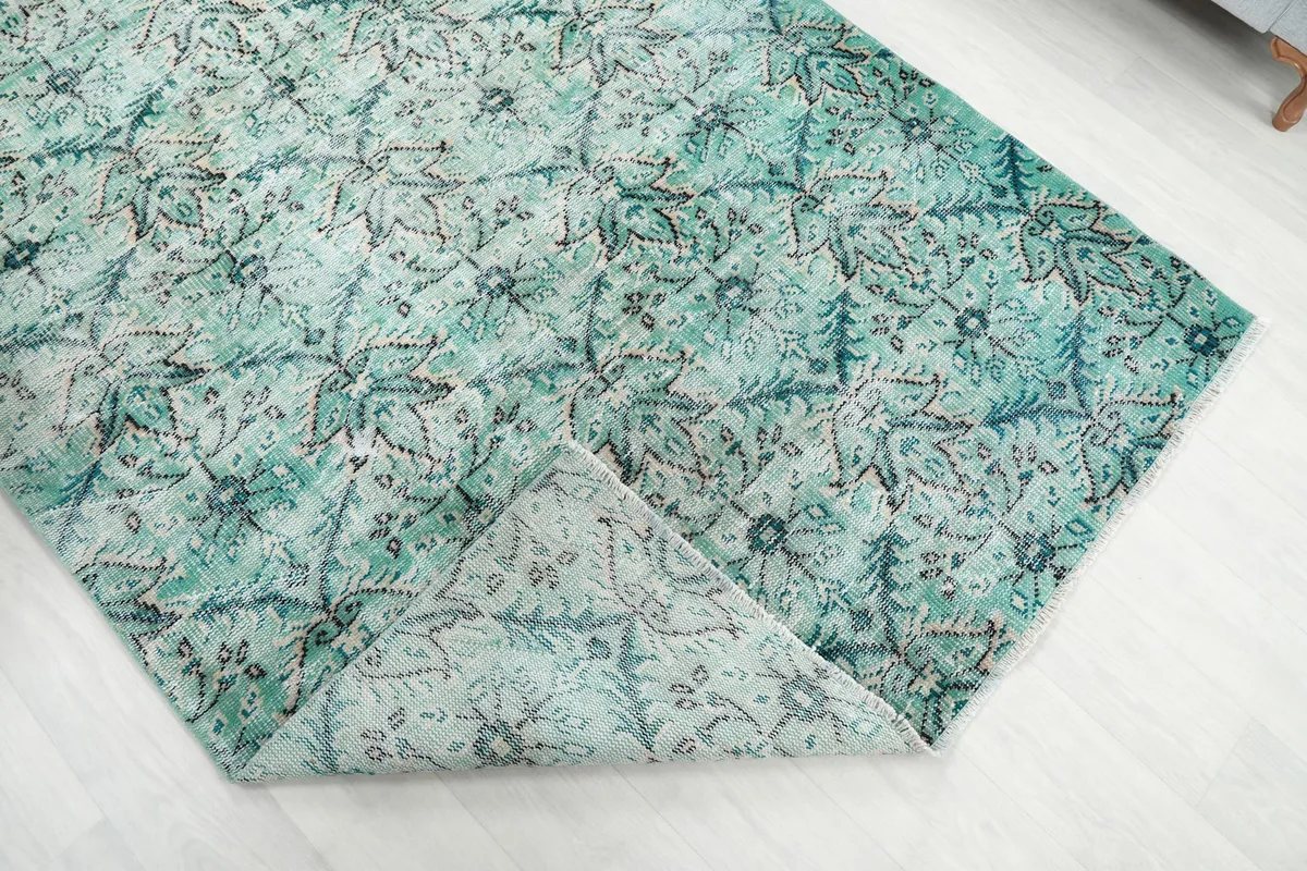 Corner of the rug folded back to reveal the back of the hand-knotted wool foundation