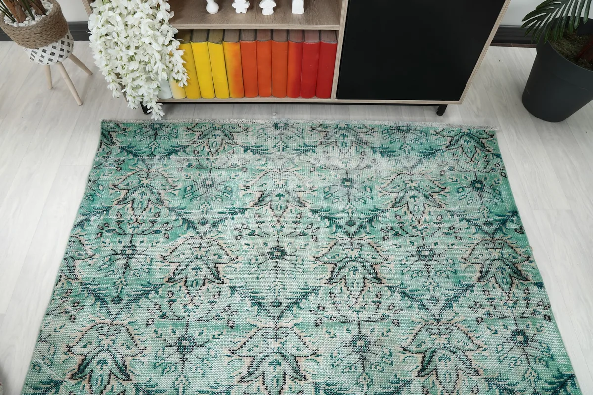 Overhead view of the green vintage rug, highlighting its overall pattern