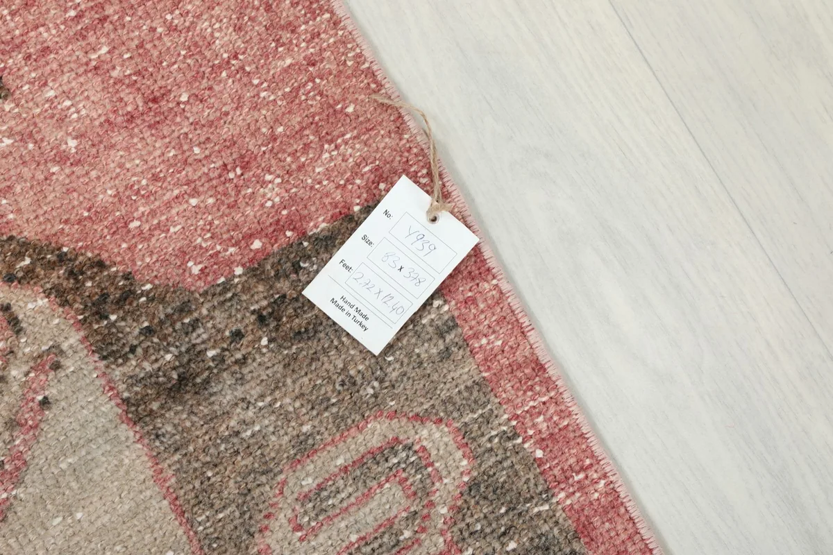Detail of the rug's surface with a product tag, showing the texture and colors of the vintage wool.