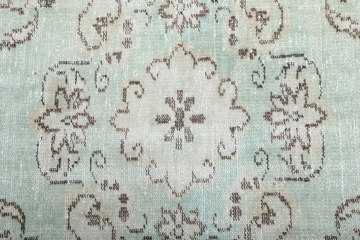 Close-up of the central floral medallion and distressed wool pile texture