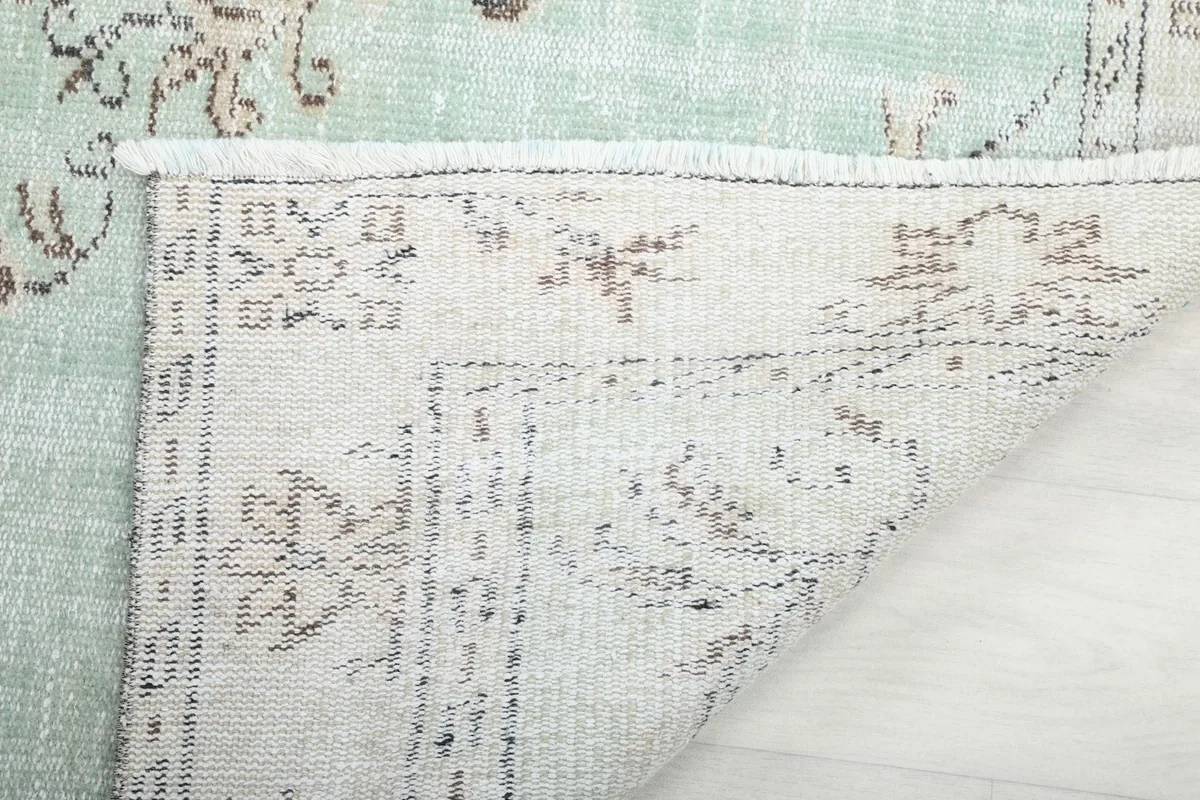 Close-up of the back of the rug, showing the hand-knotted wool on cotton foundation