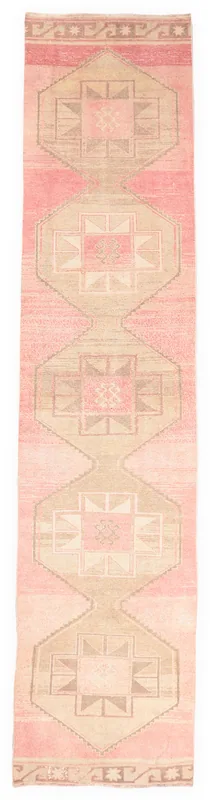 Full overhead view of a vintage rose and tan geometric Anatolian runner rug