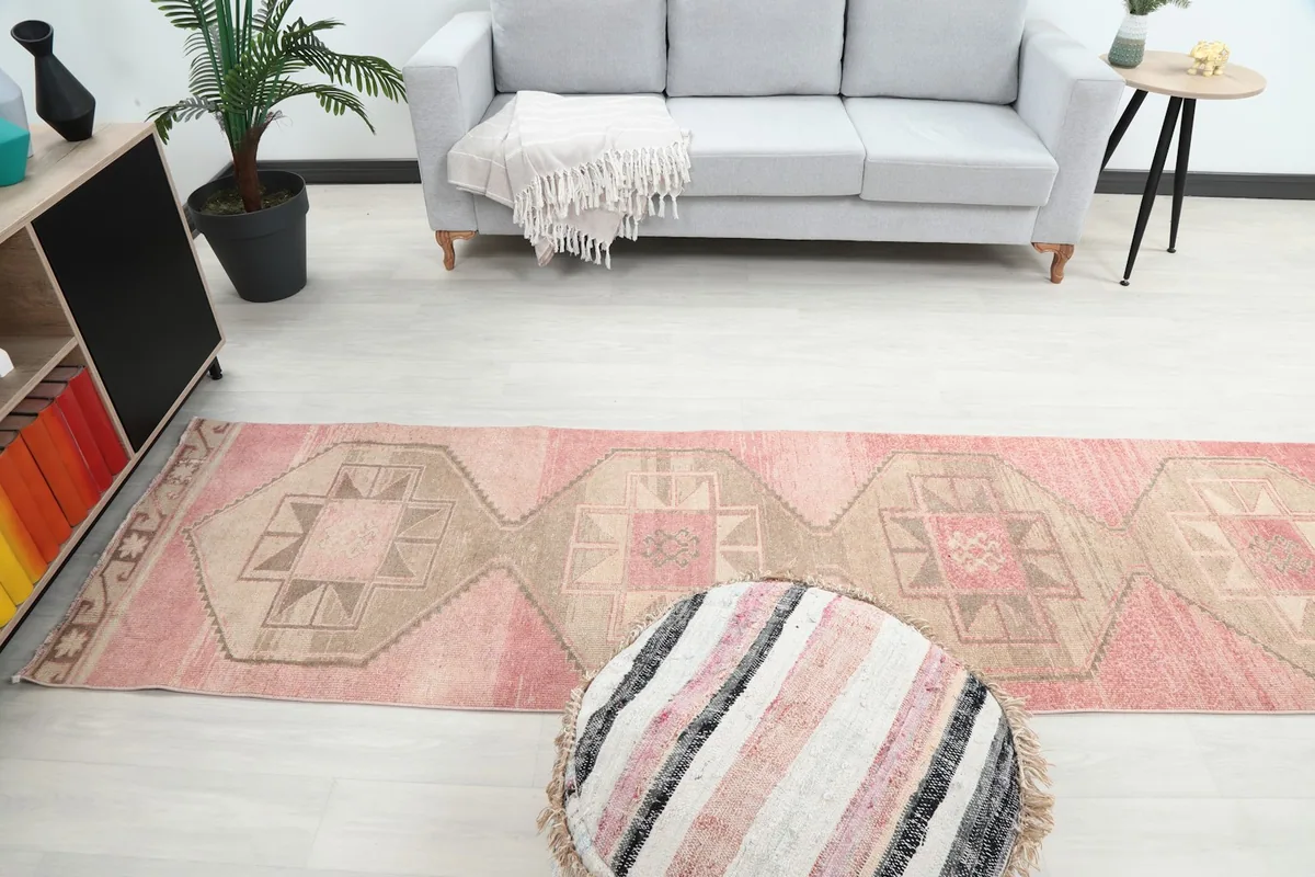 Wide shot of the room with the rose and tan runner rug as a central element