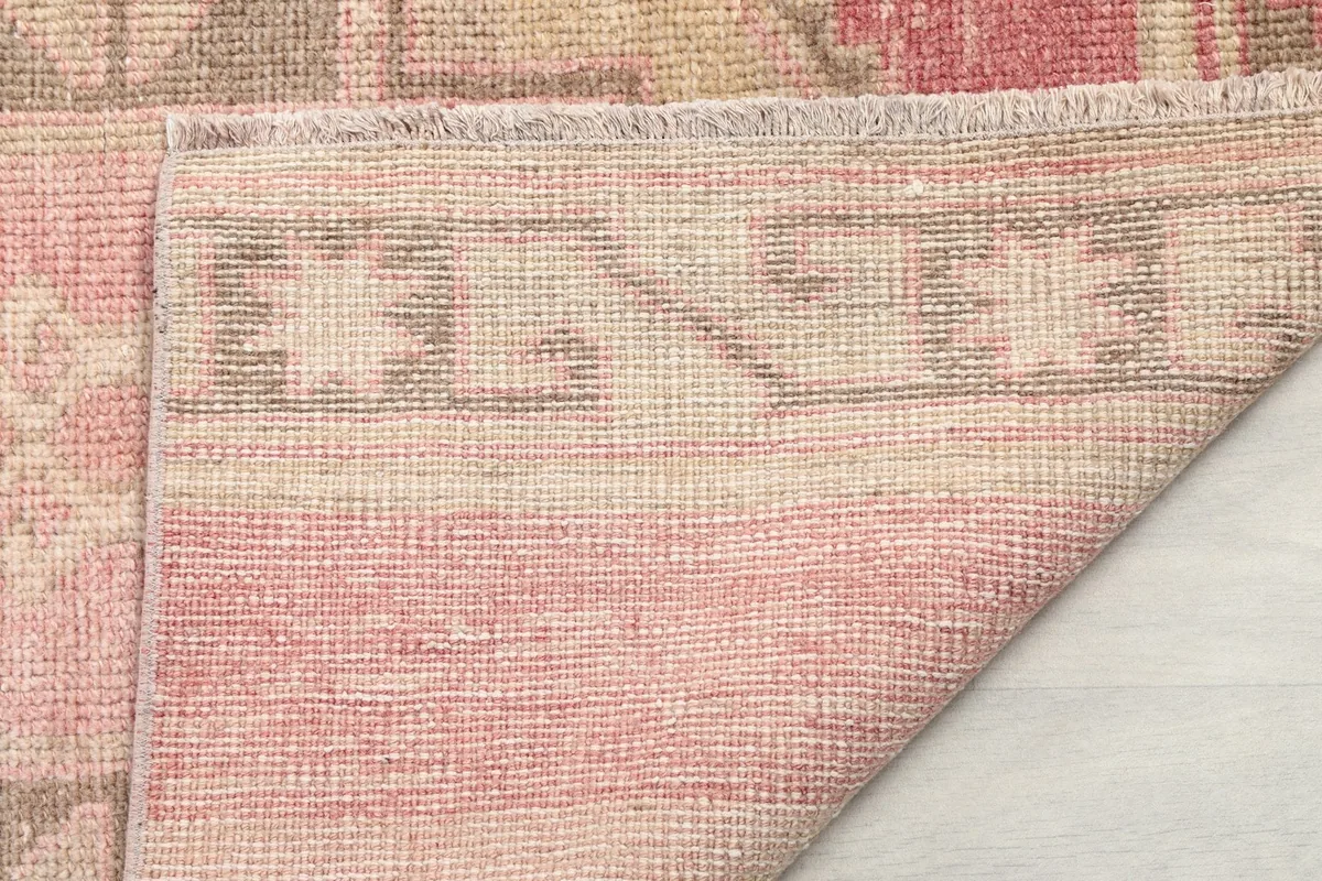 Close-up of the back of the hand-knotted runner rug, showing the cotton foundation