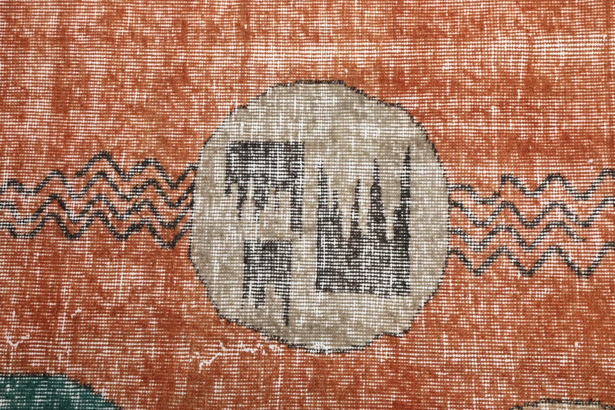 Close-up of a beige oval motif on the Rust Geometric Oval Runner, showing the intricate black patterns within.