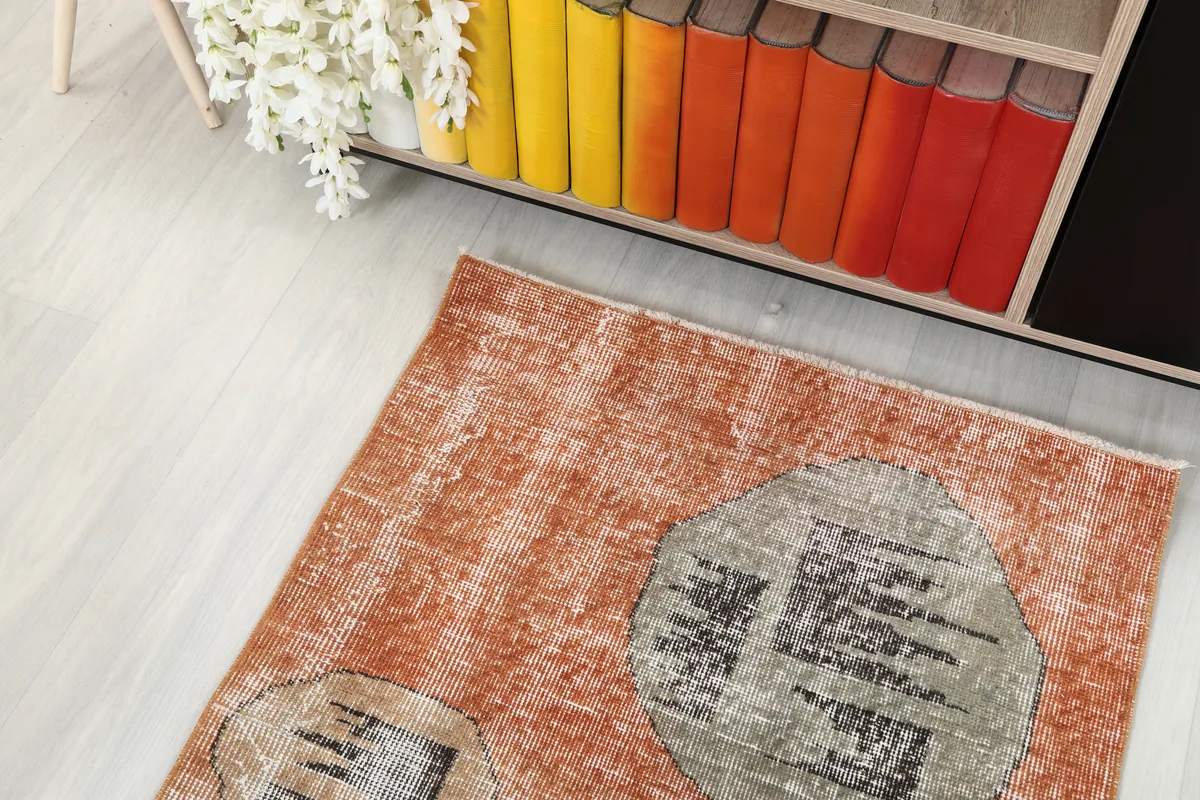 Rust Geometric Oval Runner extending from under a shelf, showcasing its vivid rust color and abstract shapes.