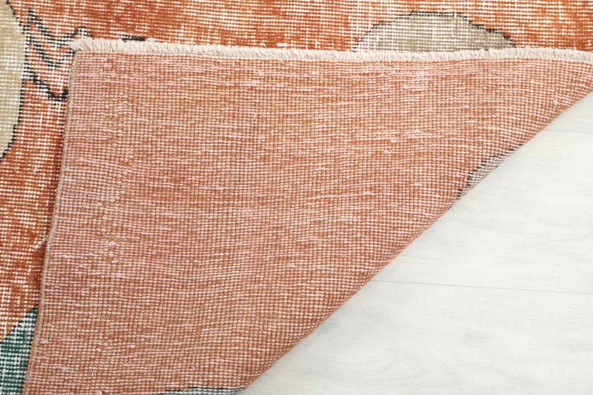 Close-up of the back of the Rust Geometric Oval Runner, detailing the tight hand-knotting on the cotton foundation.